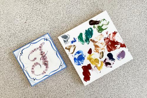 Piastrella di ceramica dipinta con colori ecologici in un laboratorio di Como