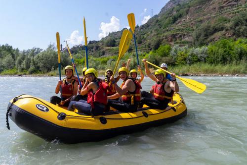 Gruppo di ragazzi si diverte durante una discesa di rafting sul fiume Adda in Valtelliva