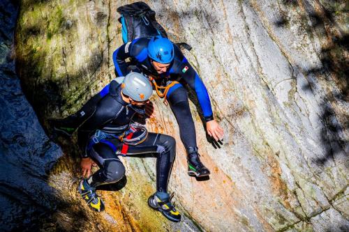 Guida alpina che spiega a un ragazzo come scendere da un toboga in Valchiavenna
