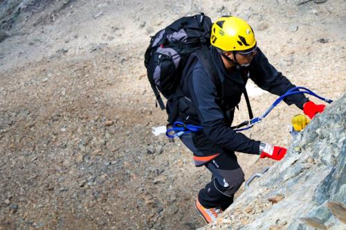 Dopo il briefing con guida alpina un ragazzo inizia la scalata della via ferrata