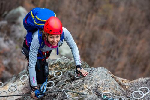 Ragazza che percorre via ferrata in Valchiavenna durante il corso base con guida alpina