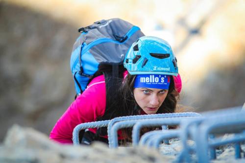 Ragazza che sale lungo una via ferrata durante il corso con guida alpina