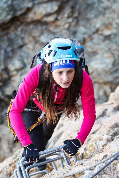 Ragazza giovane durante la scalata della via ferrata con guida alpina in Valmalenco