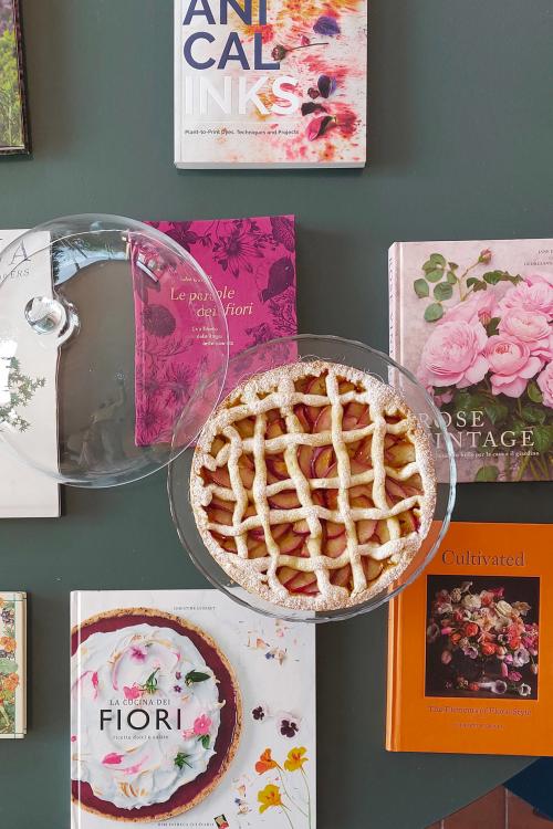 Tavolo con libri di fiori e torta crostata per aumentare l'ispirazione