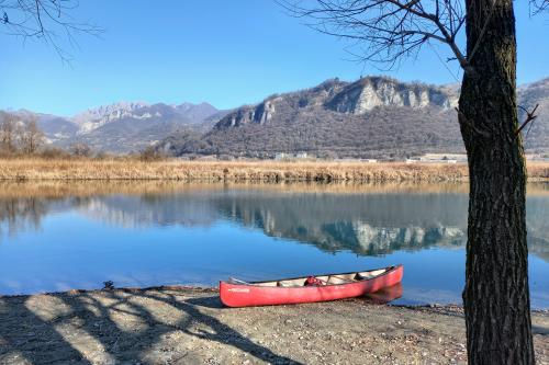 Palude del Brivio in Lombardia in primo piano una canoa canadese rossa e sullo sfondo le montagne