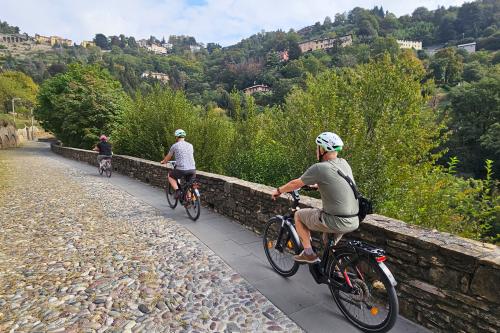 Delle persone pedalano verso un antico borgo vicino a Bergamo con guida