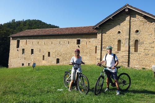 Due persone in posa con due bici di fronte ad un antico palazzo nei dintorni di Bergamo