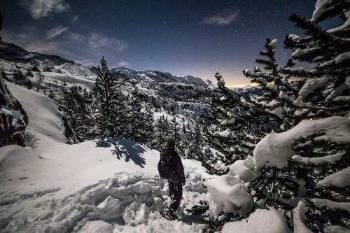 Una persona sulle ciaspole osserva il paesaggio innevato in Valmalenco in Lombardia