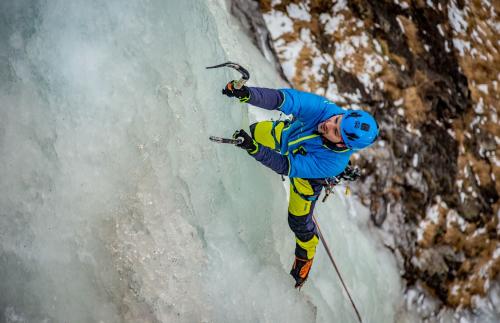 Un ragazzo sta facendo ice climbing su una parete rocciosa ghiacciata in Valmalenco in Lombardia