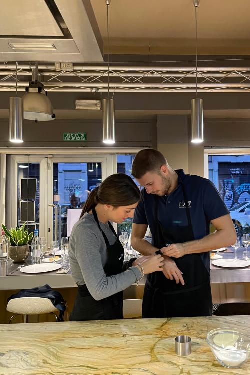 Due ragazzi giovani si stanno preparando per iniziare la loro cooking class di coppia a Milano
