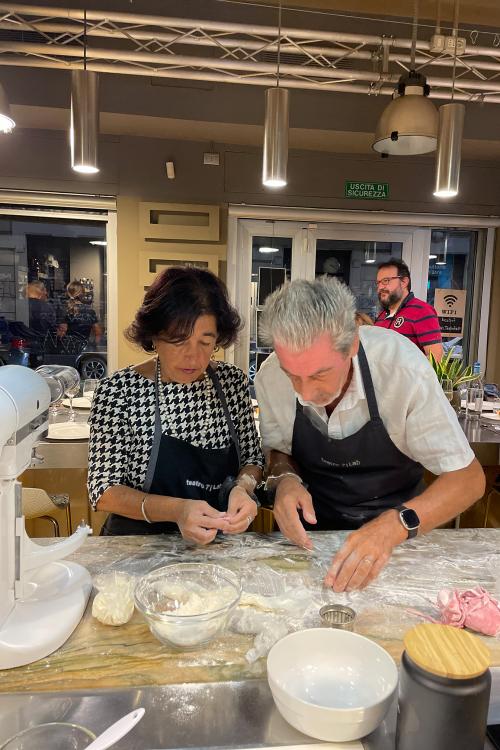 Una coppia di persone di mezza età stanno facendo insieme un corso di cucina a Milano