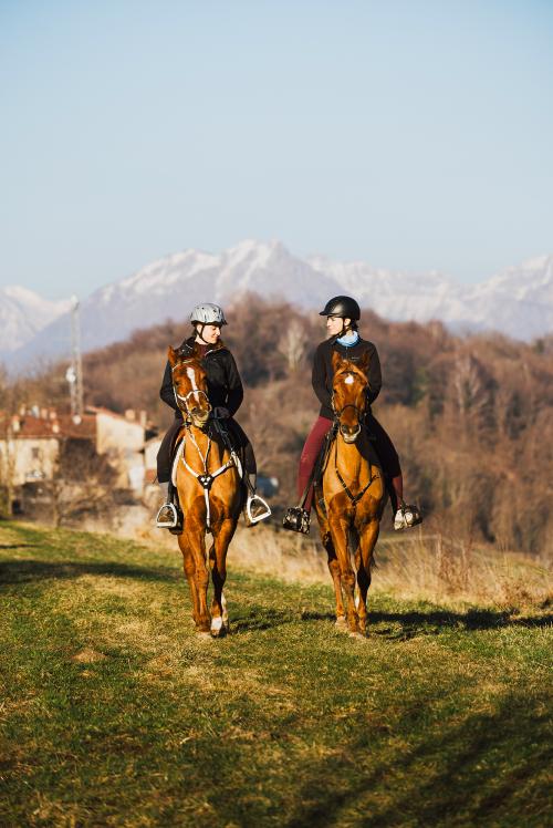 Due ragazze durante una passeggiata a cavallo vicino al Lago di como