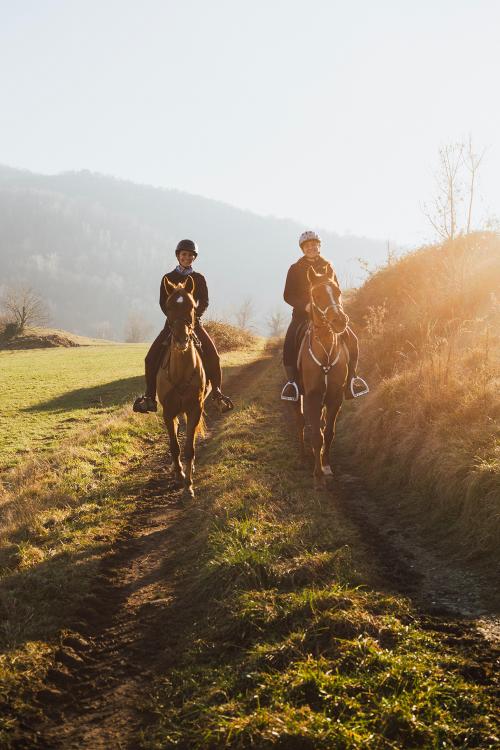 Due ragazze passeggiano a cavallo durante una fredda giornata invernale