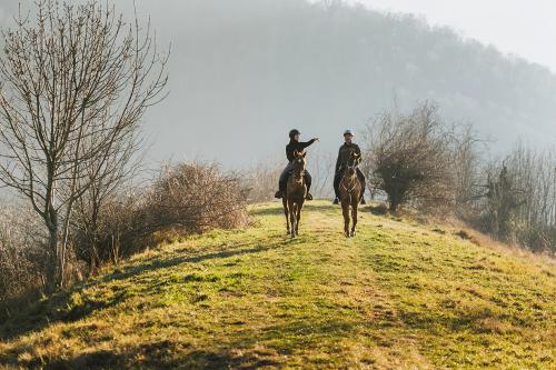 Due ragazzi su di una collina stanno facendo una passeggiata a cavallo