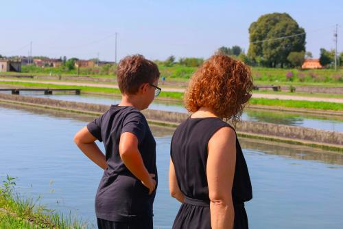 Una mamma e un bambino stanno partecipando alla visita guidata all'allevamento di una azienda ittica nel Parco del Mincio vicino Mantova