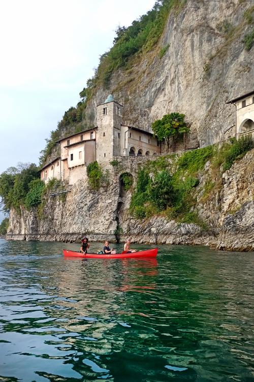 Sul Lago Maggiore vicino all'Eremo di Santa Caterina dei ragazzi pagaiano a bordo di una canoa canadese