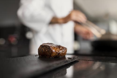 Uno chef professionista mostra come cuocere la carne durante un corso di cucina a Milano in Lombardia