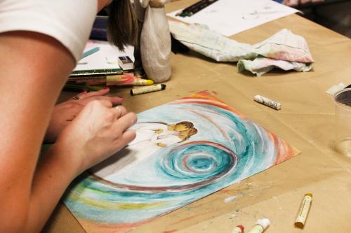 Una ragazza disegna con i pastelli ad olio durante un corso vicino a Como in Lombardia