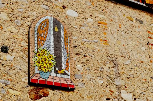 Il muro di una casa di Brenta in Lombardia vicino il Lago Maggiore sulla quale è stato appeso un mosaico che rappresenta una finestra aperta e dei fiori