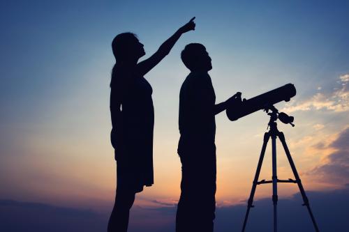 La siluette di due ragazzi che osservano il cielo con un telescopio in una calda sera d'estate in Oltrepò Pavese in Lombardia