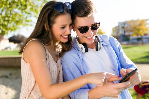 Due ragazzi stanno guardando un cellulare mentre partecipano ad un'escape game urbano nel centro della città di Brescia in Lombardia