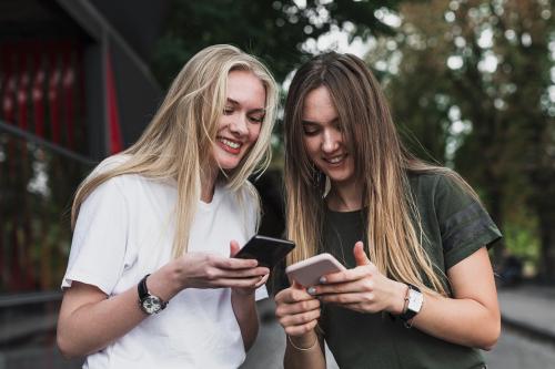 Due ragazze che sorridono mentre si divertono a giocare all'escape game urbano nel centro storico di Desenzano del Garda in Lombardia