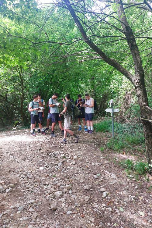 Un gruppo di ragazzi stanno partecipando ad una esperienza di orienteering in un bosco non lontano dal Lago di Garda in Lombardia