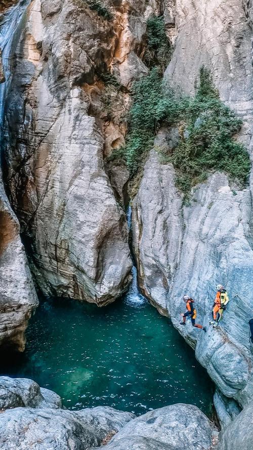 Dei ragazzi durante una esperienza di canyoning nel torrente Campione vicino al Lago di Garda in Lombardia si tuffano in una vasca d'acqua tra le rocce