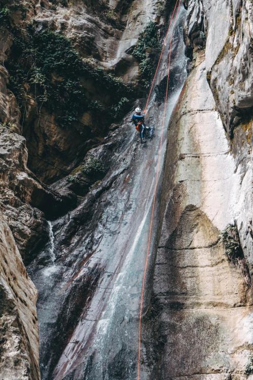 Un ragazzo durante una escursione di canyoning in Lombardia mentre si cala da una cascata