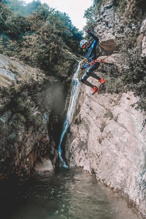 Un ragazzo durante una esperienza di canyoning vicino il Lago di Garda in Lombardia si tuffa da una roccia