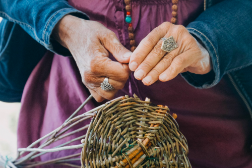 Una donna che durante un corso di cesteria e intreccio sul Lago di Como realizza il suo cesto con salice naturale