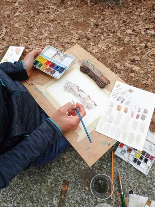 Una ragazza dipinge nel bosco in Lombardia durante il workshop en plein air di acquerello