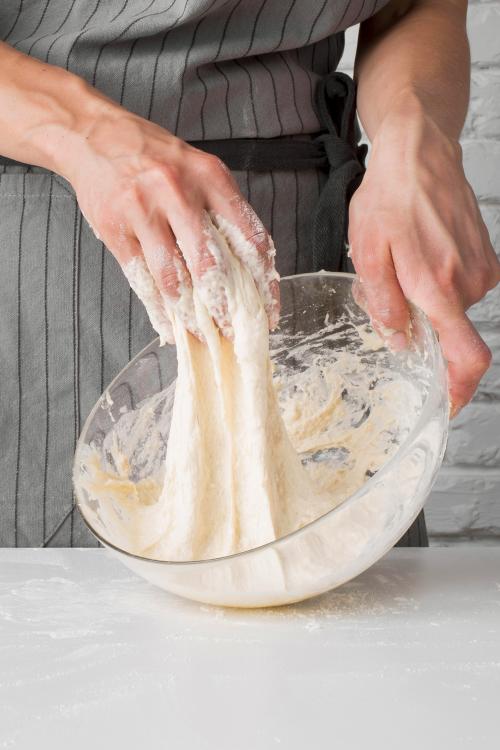 Una donna mentre manipola lievito madre acqua e farina per preparare il pane durante il laboratorio di panificazione vicino a Varenna sul Lago di Como in Lombardia