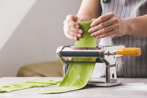 Una ragazza durante il corso per imparare a preparare la pasta fresca con erbe selvatiche in Lombardia vicino Varenna.jpg