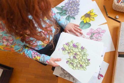 Una artista illustratrice osserva i disegni fatti dai partecipanti durante il corso di illustrazione botanica a Milano in Lombardia