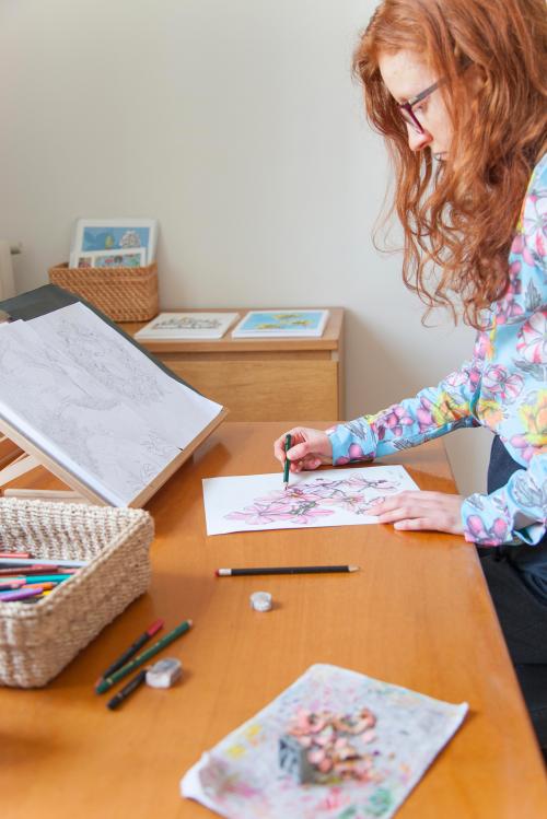 Una ragazza mentre disegna elementi naturali durante il corso di illustrazione botanioca su carta con matite a Milano in Lombardia