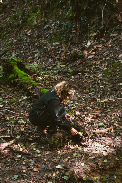 Una donna durante una esperienza di forest bathing nella Valle del Curone in Lombardia cerca una connessione con la natura circostante
