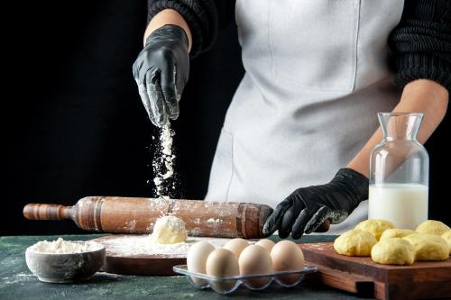 Donna mentre utilizza farina latte uova zucchero per creare l'impasto per creare dei dolci durante il corso di pasticceria a Milano