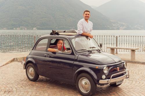 Una coppia di ragazzi su una Fiat 500 d'epoca durante un tour sul Lago di Como in Lombardia