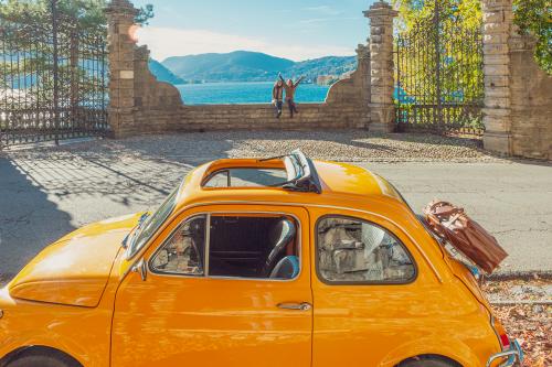 Due ragazze durante un tour del Lago di Como in Lombardia con una Fiat 500 gialla noleggiata in città