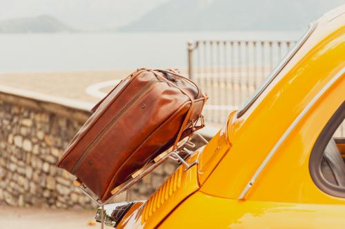 Particolare del portapacchi di una Fiat 500 d'epoca gialla noleggiata a Como in Lombardia