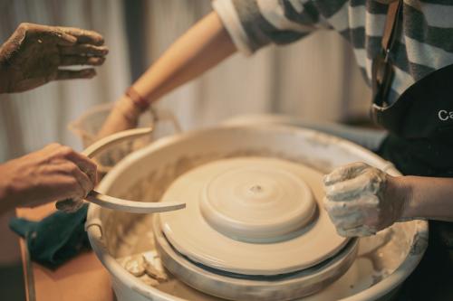 Due ragazze durante il laboratorio di ceramica per realizzare due bicchieri con il tornio in Valchiavenna in Lombardia