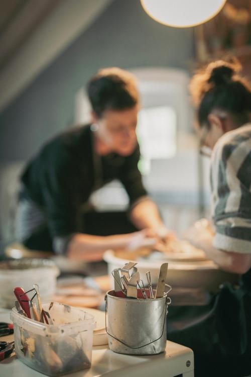 Due ragazze che realizzano dei bicchieri in ceramica con l'utilizzo del tornio in Valchiavenna in Lombardia