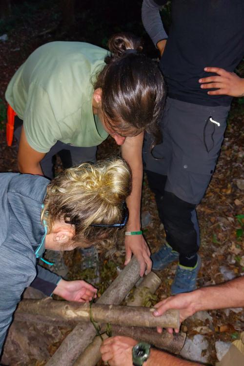 Delle ragazze stanno costruendo un riparo per la notte durante il corso di survival vicino Bergamo in Lombardia