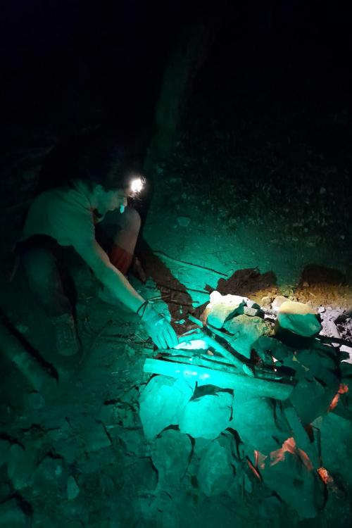 Un ragazzo che sta partecipando al corso di survival di 24 ore vicino Bergamo in Lombardia durante la notte mantiene acceso il fuoco