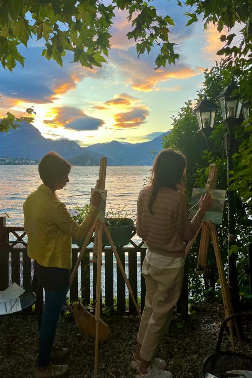 Due ragazze dipingono al tramonto sul Lago di Como in Lombardia durante il corso di pittura en plein air con i colori ad olio