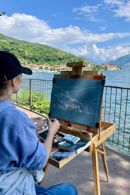 Durante il corso di pittura en plein air sul Lago di Como sopra Varenna in Lombardia una ragazza dipinge dal vero