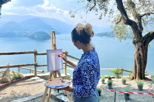 Una ragazza che dipinge en plein air su una tela bianca in Lombardia al Castello di Vezio sul Lago di Como