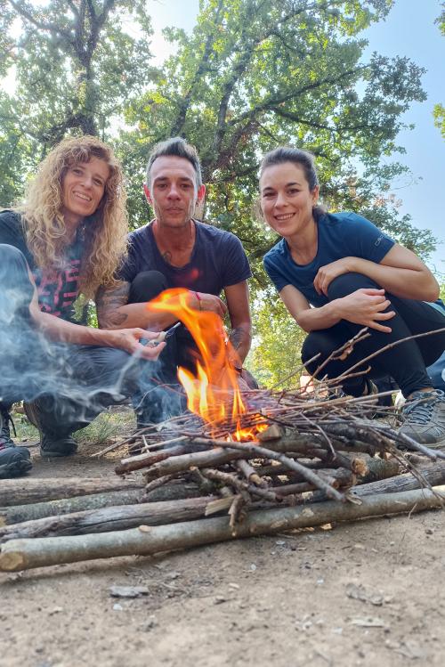 Delle persone imparano ad accendere un fuoco durante il corso di survival vicino al Lago di Garda in Lombardia