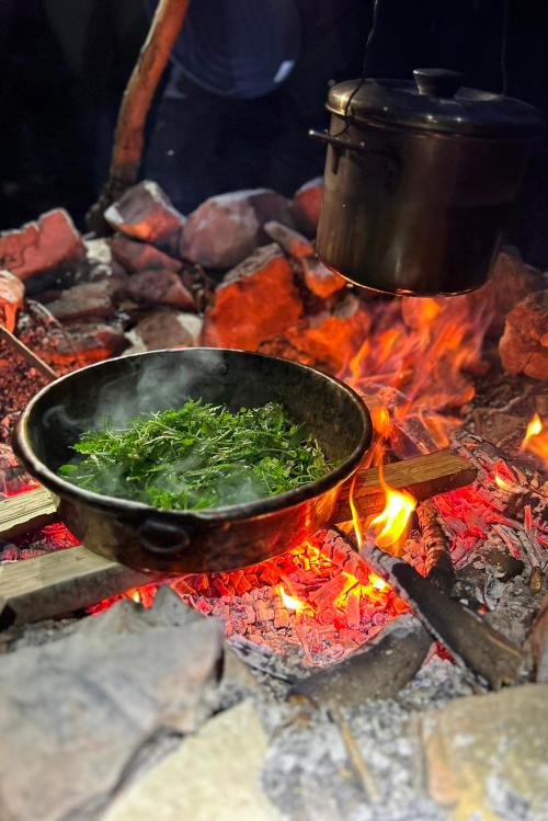 Cena preparata direttamente sul fuoco durante il corso di survival vicino Brescia sul Lago di Garda